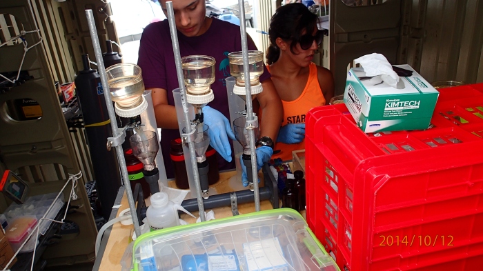 Researchers Natalie Cohen and Carly Moreno in their on-board lab with water filtration setup.